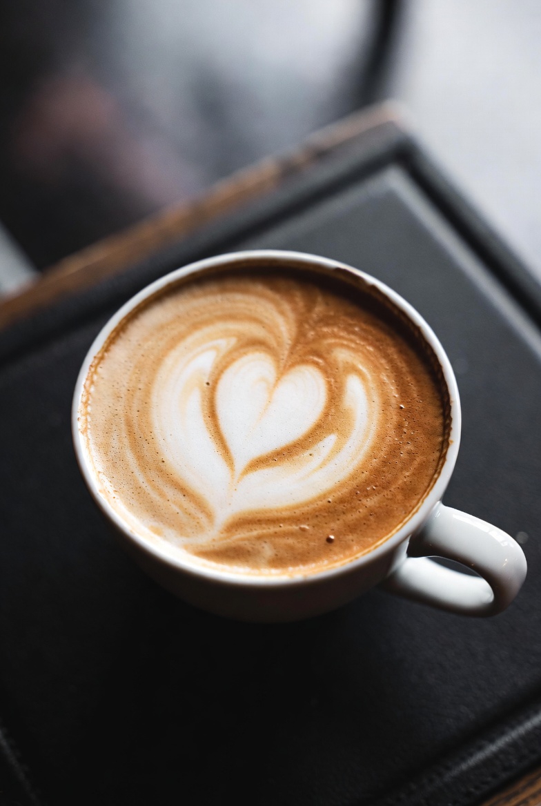 Cremiger Cappuccino mit kunstvoller Latte Art in einer grünen Tasse